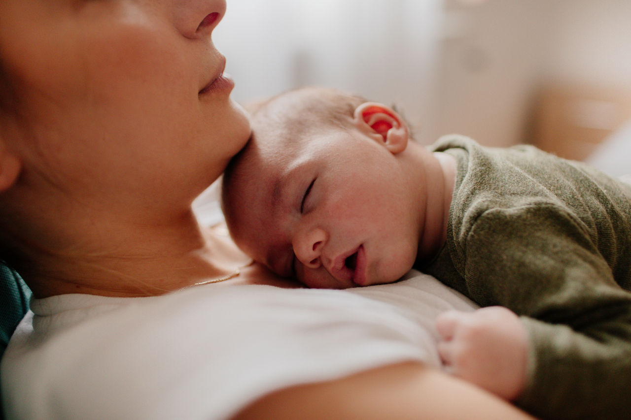 Baby schläft auf Brust von Mutter