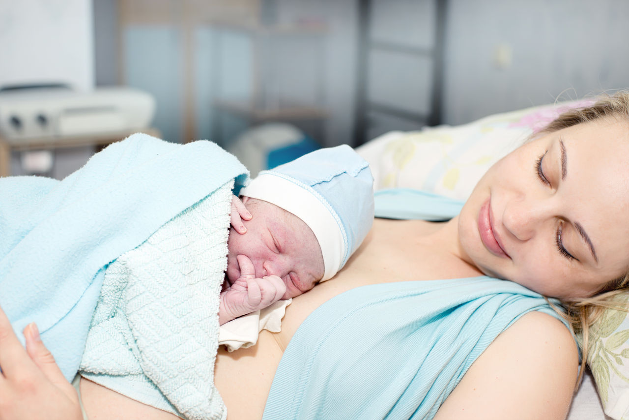 Mutter hält Neugeborenes im Krankenhaus