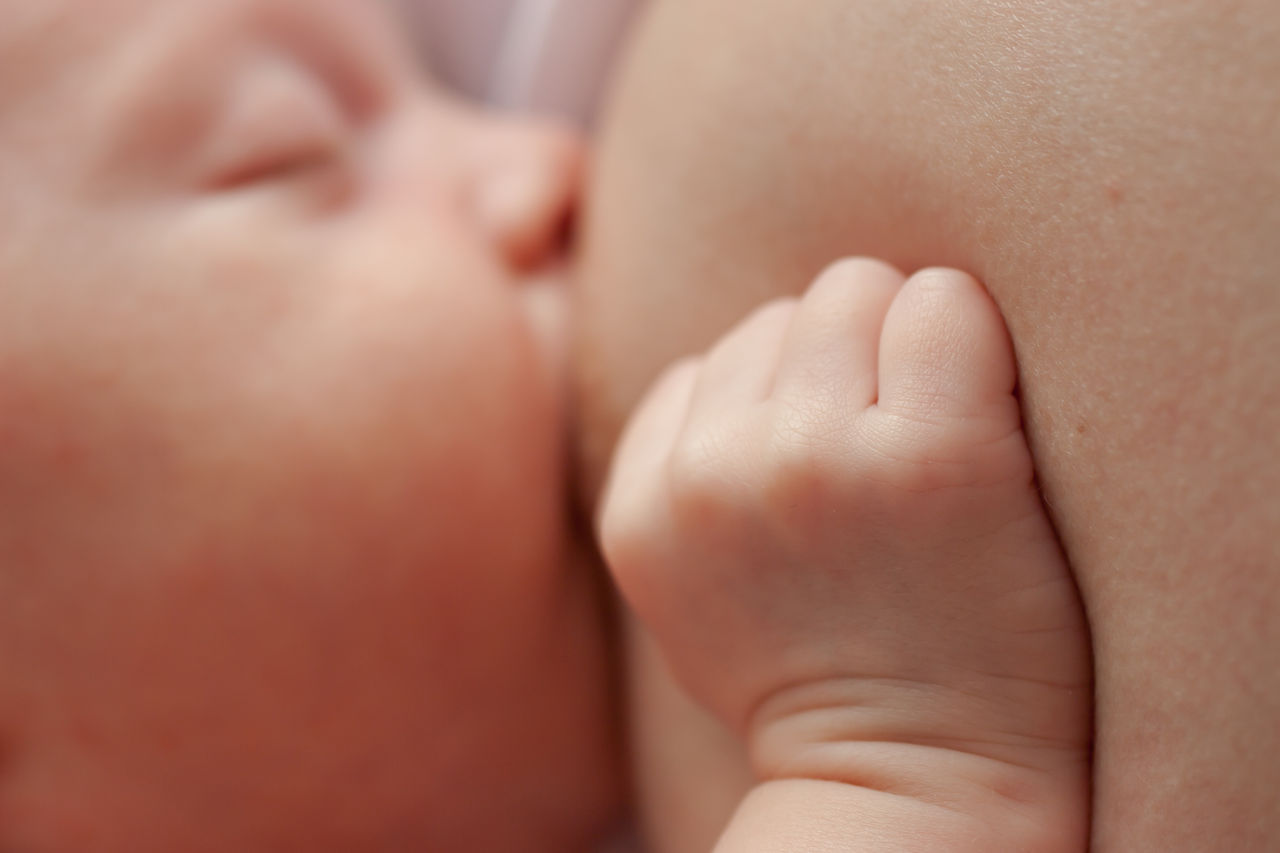 Baby in Nahaufnahme beim Stillen an der Brust.