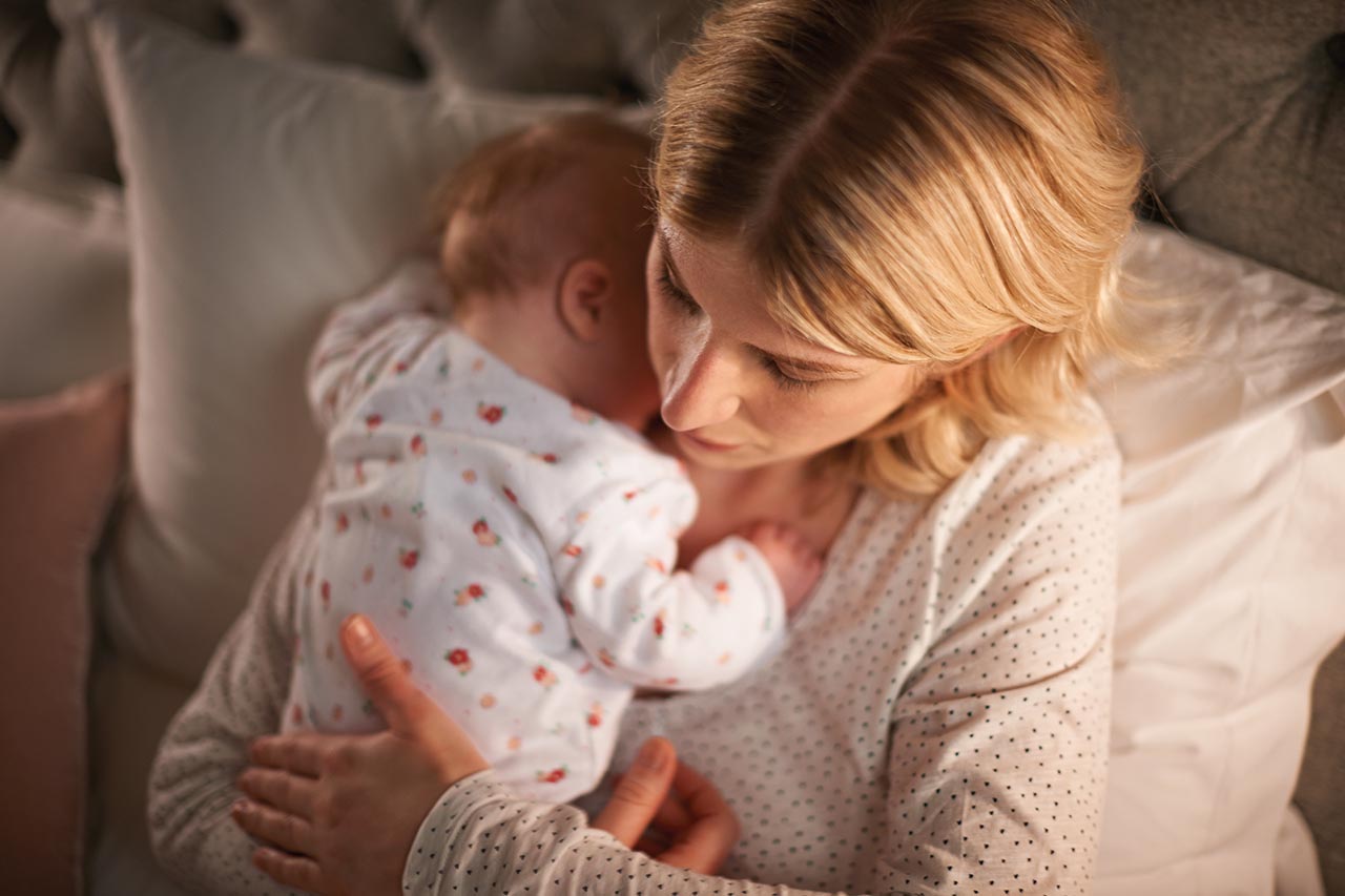 Baby schläft auf Brust von Mutter