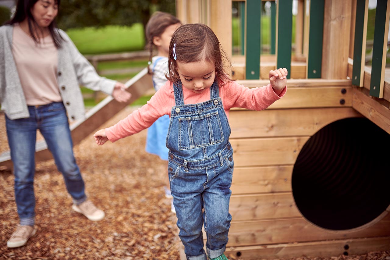 Kleinkind balanciert auf dem Spielplatz