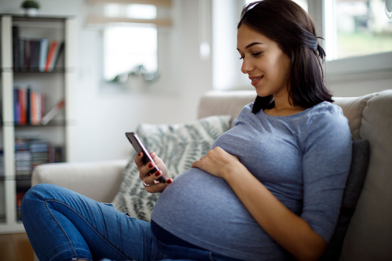 Pregnant woman checking smartphone
