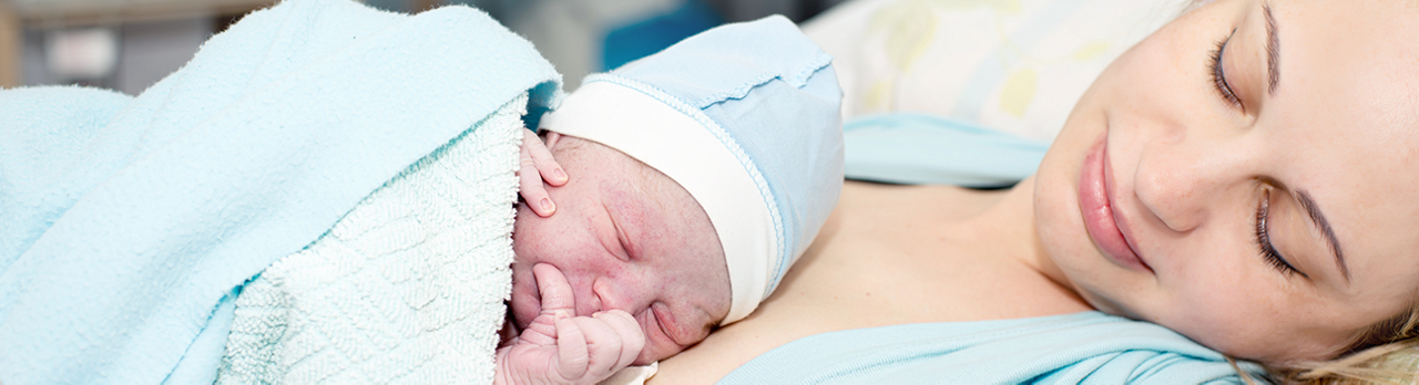 Mutter hält Neugeborenes im Krankenhaus 
