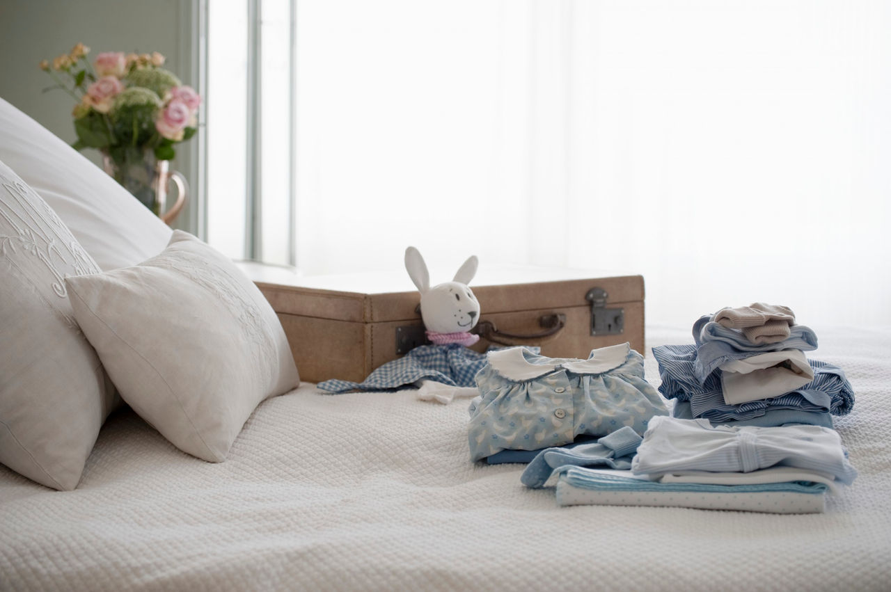 Bett mit gefalteten Klamotten drauf