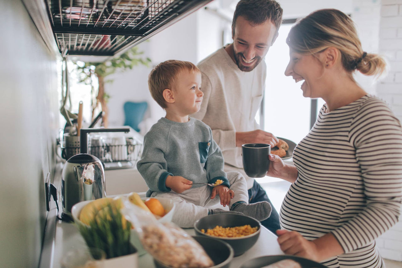 Schwangere Frau kocht mit Sohn